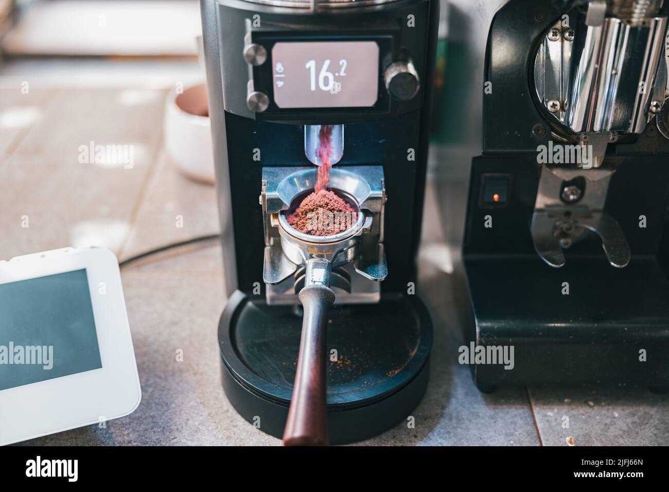 Processus de broyage des grains de café versant dans un porte-filtre à l'aide d'une machine à café Banque D'Images