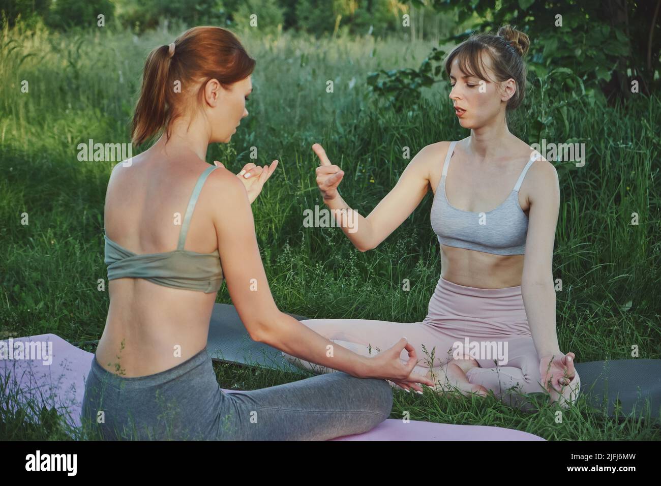 Entraîneur personnel de yoga enseigne les pratiques de respiration de jeune femme, à l'extérieur Banque D'Images