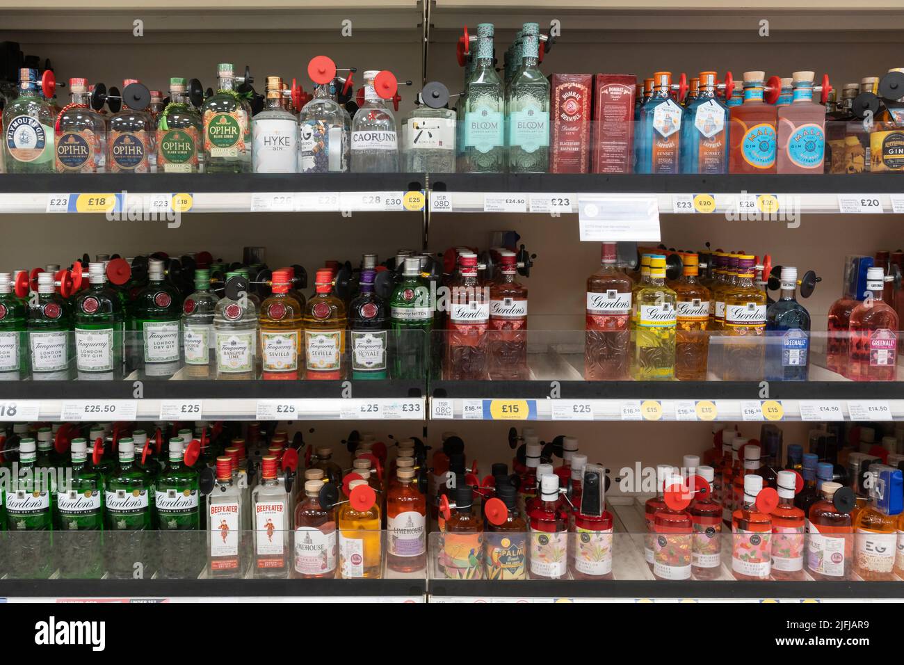 Bouteilles de gin de sécurité étiquetées pour la vente sur les étagères de supermarché à Tesco. ROYAUME-UNI Banque D'Images