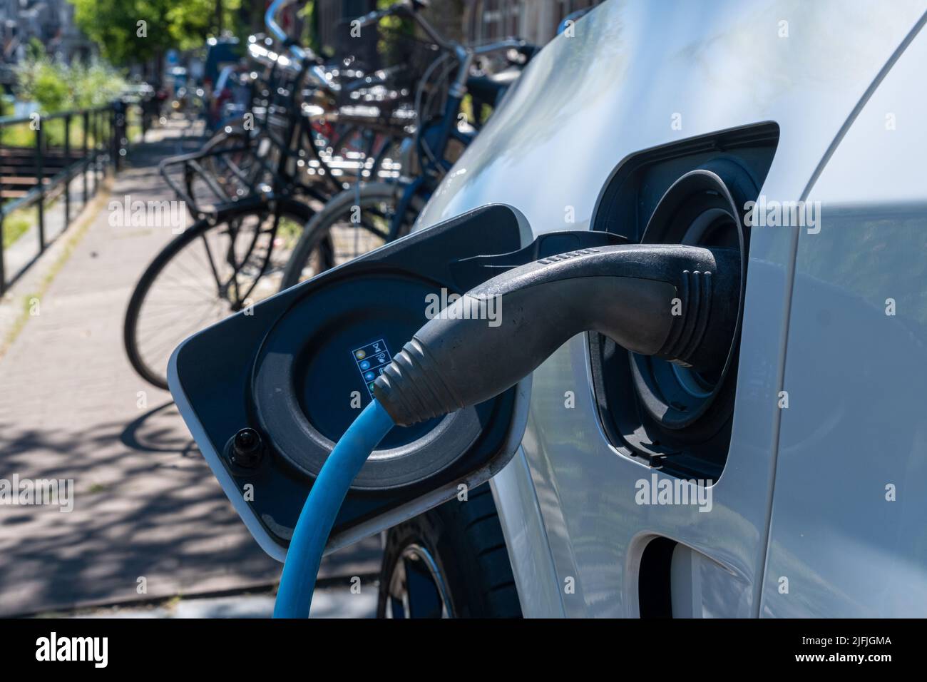 Voiture électrique branchée et recharge à proximité des vélos à Amsterdam Banque D'Images