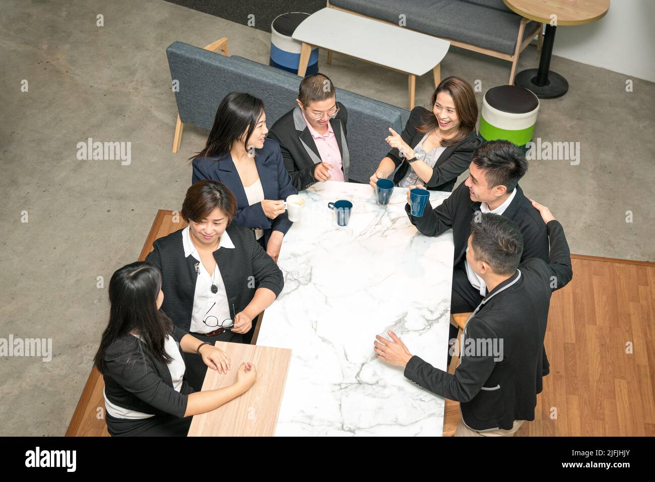 Collègues de bureau ayant une discussion informelle autour de la table et du café. Vue de dessus grand angle. Banque D'Images