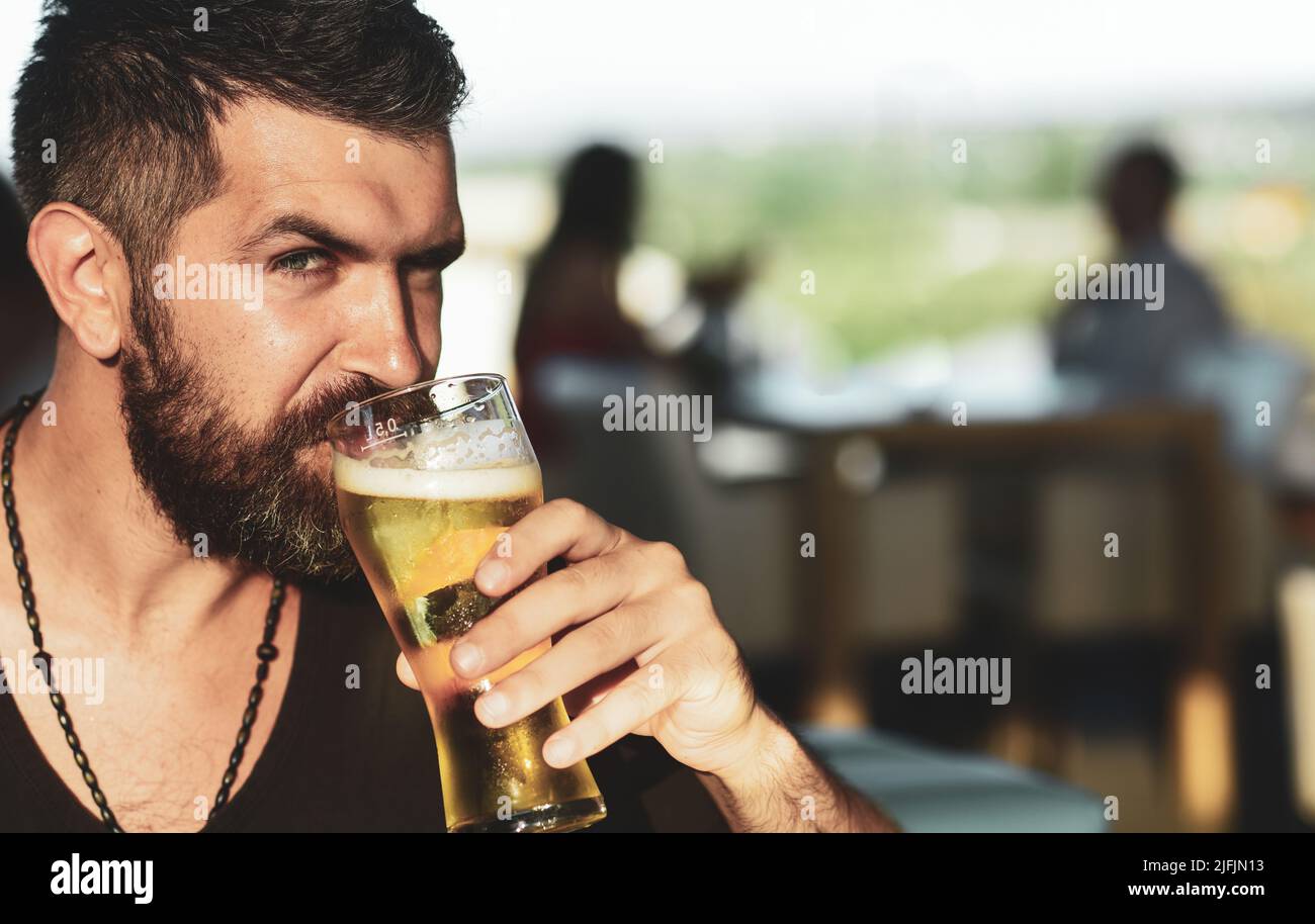 Un homme barbu d'hipster brutal s'assoit au comptoir du bar. Bars et pubs de bière Banque D'Images