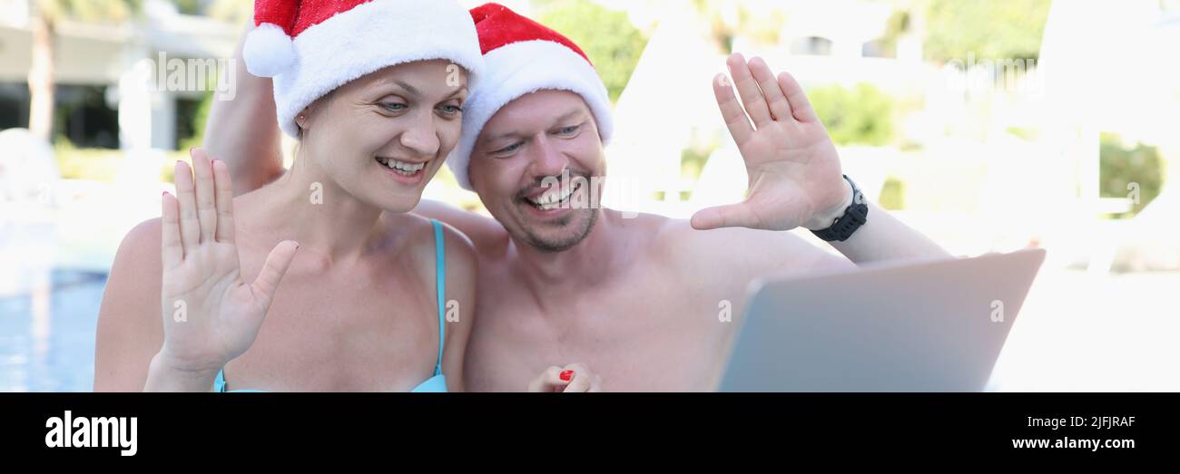 Un homme et une femme du père noël chapeaux dans la piscine Banque D'Images
