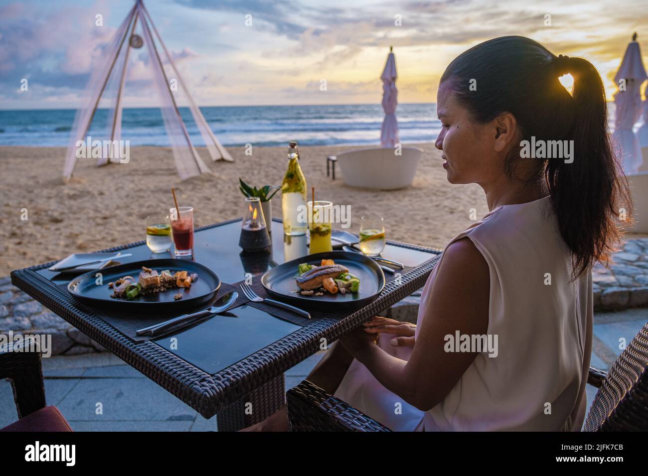 Femme asiatique dîner au coucher du soleil sur la plage à Phuket Thaïlande Khao Lak Banque D'Images
