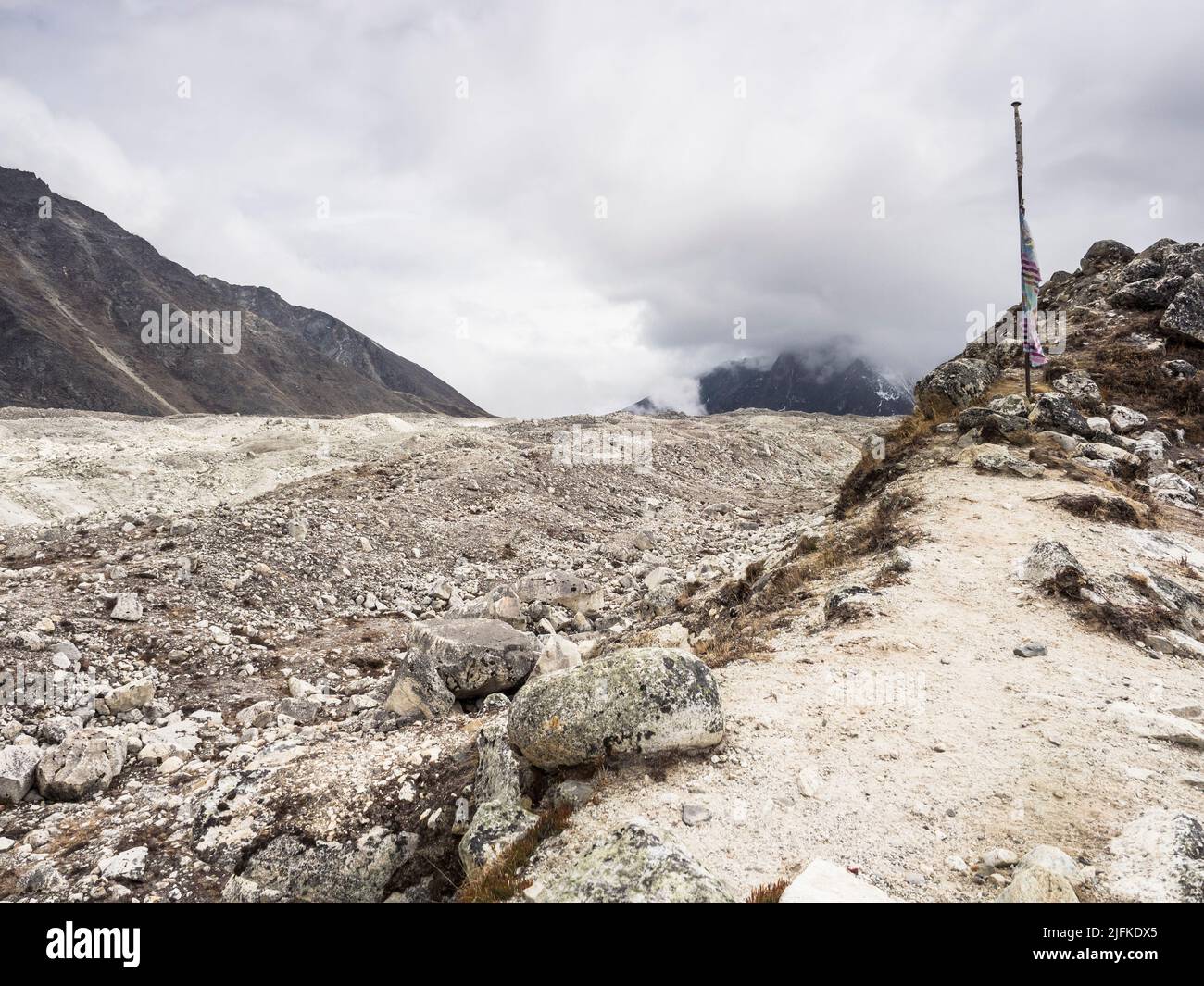 Drapeau de prière sur la moraine montrant la route à travers le glacier de Khumbu jusqu'à la Kongma la (5535m) de Lobuche (4940m) Banque D'Images