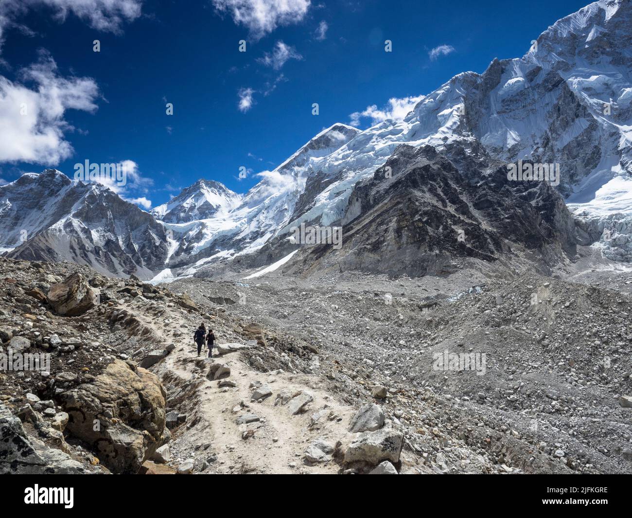Randonneurs sur la route vers le camp de base de l'Everest le long de la moraine du glacier de Khumbu. Khumbutse (6636m) (l), Changtse (7543m) et l'épaule ouest sont visibles Banque D'Images
