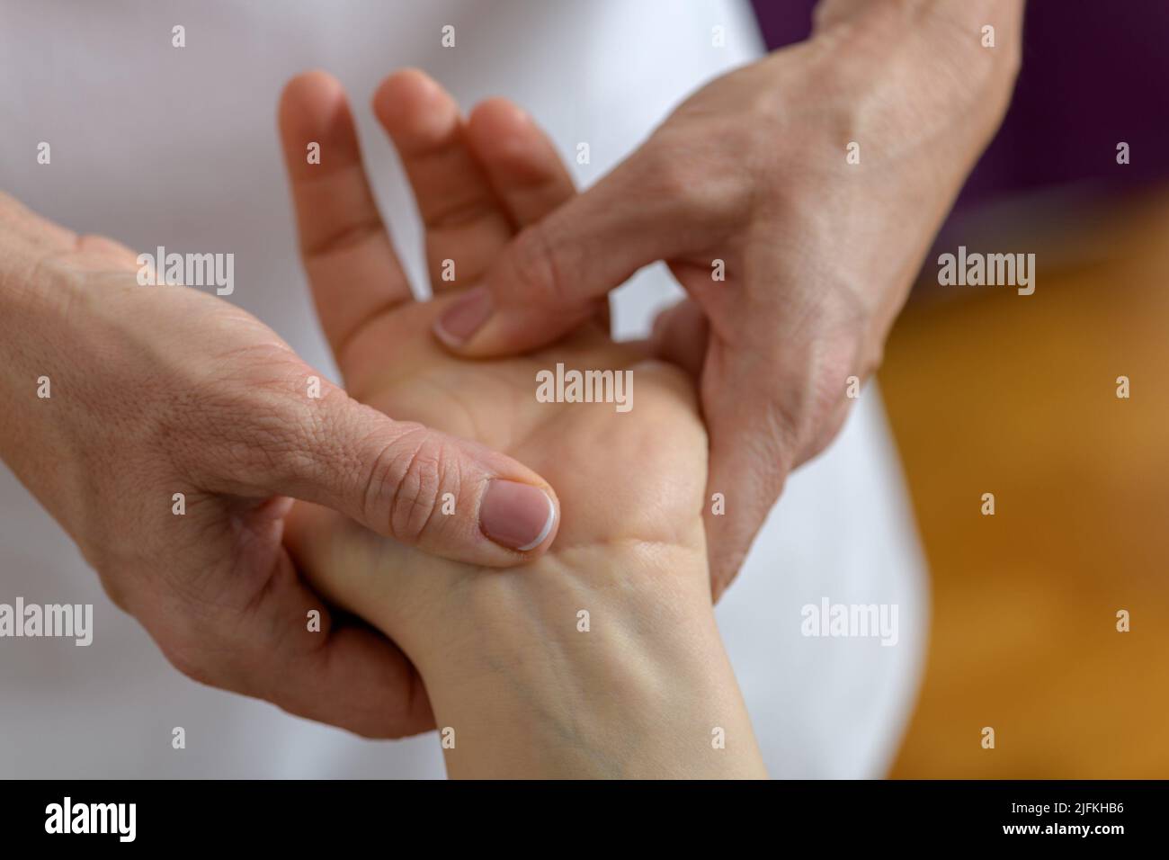 Photo rapprochée d'une main d'une femme caucasienne de 30-35 ans posée sur une table de massage et recevant un massage des mains et des pieds et une acupression spéciale Banque D'Images