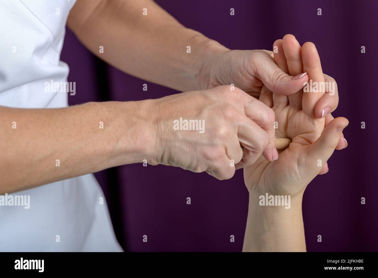 Photo rapprochée d'une main d'une femme caucasienne de 30-35 ans posée sur une table de massage et recevant un massage des mains et des pieds et une acupression spéciale Banque D'Images