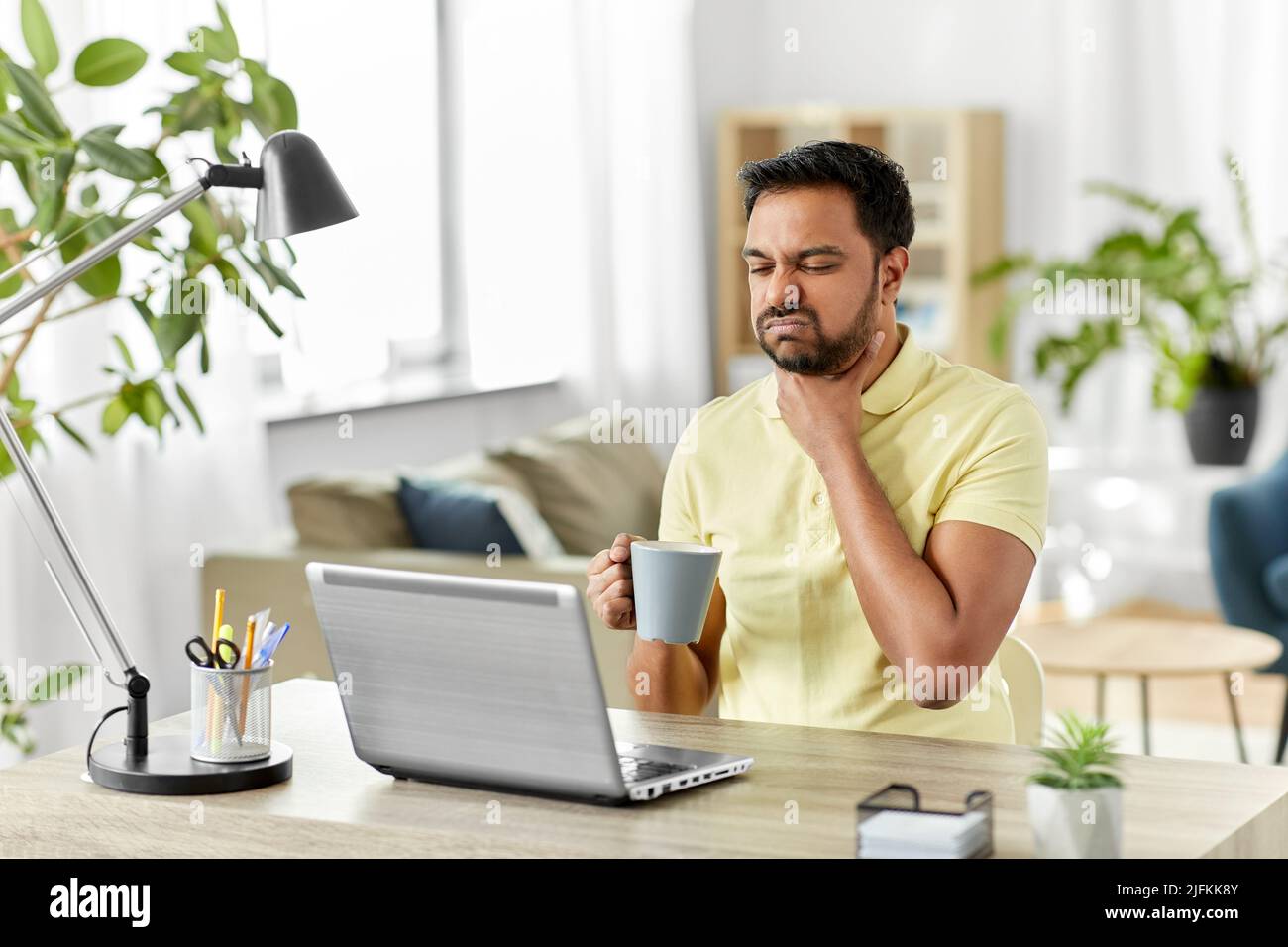 homme indien malade avec mal de gorge travaillant à la maison Banque D'Images