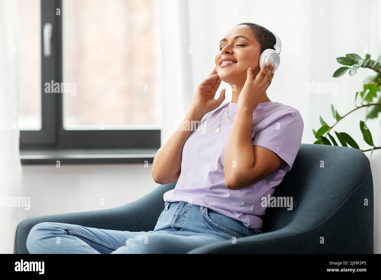 femme dans un casque qui écoute de la musique à la maison Banque D'Images