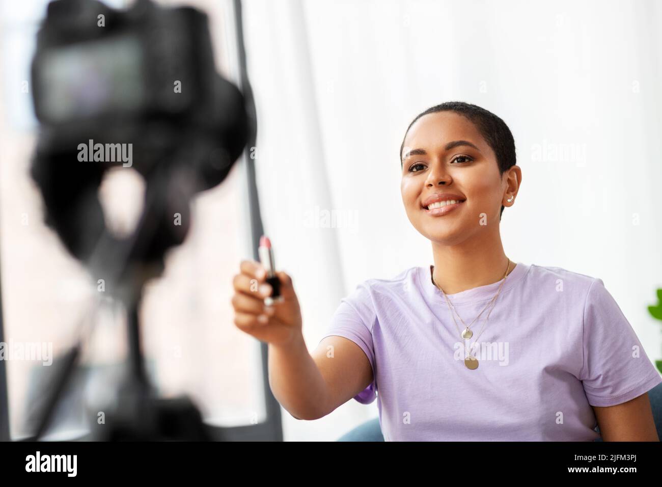 femme blogueur de beauté avec appareil photo et rouge à lèvres Banque D'Images