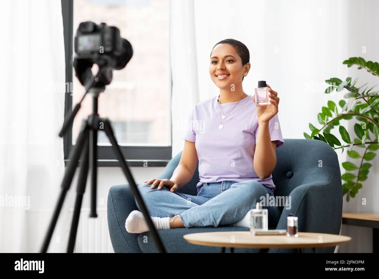femme blogueur de beauté avec appareil photo et parfum Banque D'Images