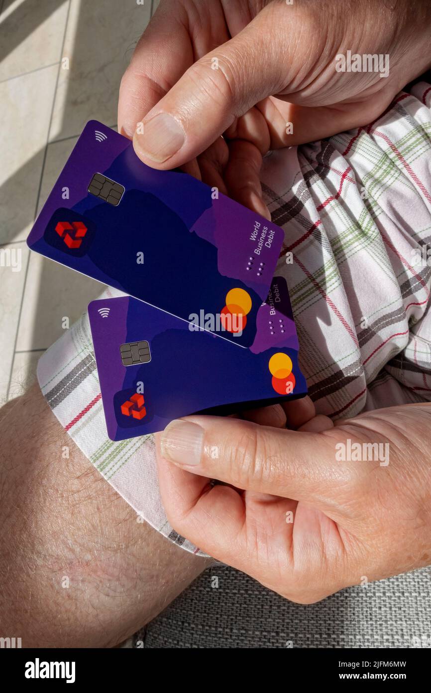 Gros plan des mains de la personne homme tenant Natwest Bank Business Banks cartes de débit cartes sans contact Angleterre Royaume-Uni GB Grande-Bretagne Banque D'Images