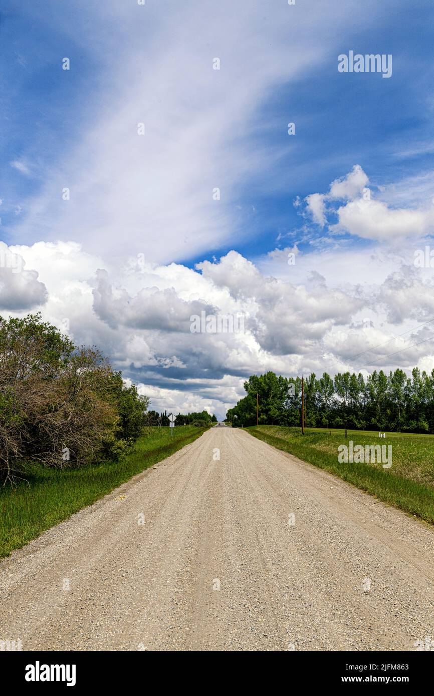 Cirrus Fibratus et cumulus humilis nuages sur une route de gravier rurale Banque D'Images