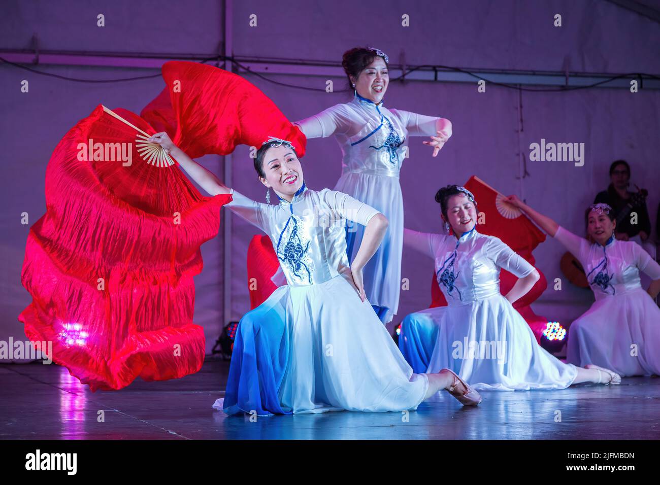 Des femmes chinoises dans des robes de Cheongsam exécutant une danse de ventilateur pendant les célébrations de la mi-automne Festival. Auckland, Nouvelle-Zélande Banque D'Images