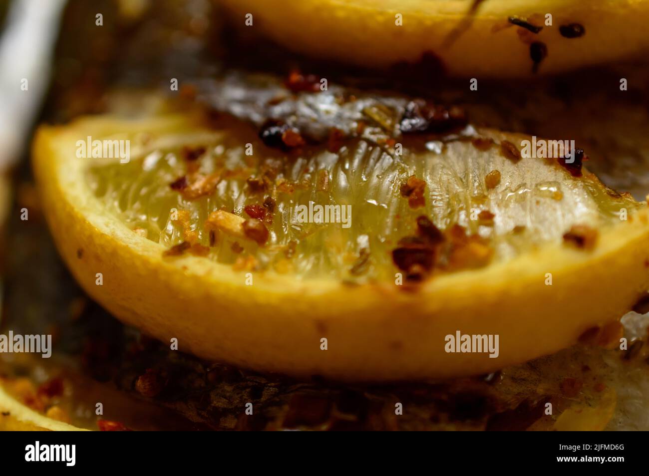 Macro photo d'un citron avec des épices sur le dessus du poisson dorado. Poisson espar doré recouvert de citrons. Banque D'Images