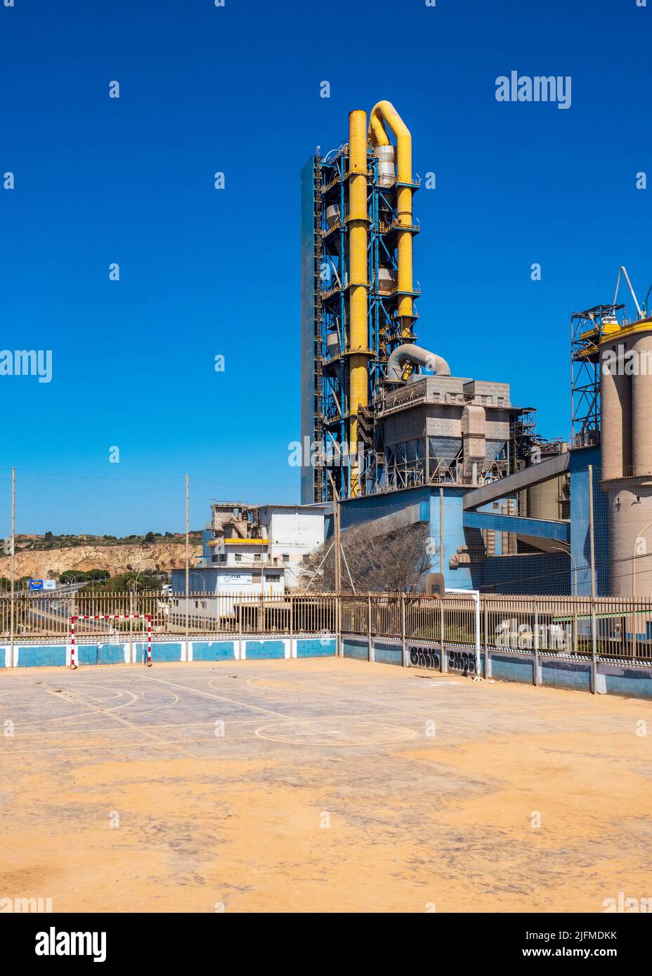 Usine de ciment à un terrain de sport d'école Banque D'Images