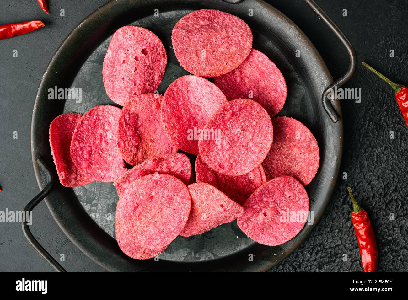 Chips de pommes de terre rouges sur fond noir de table en pierre foncée, plan de dessus Banque D'Images