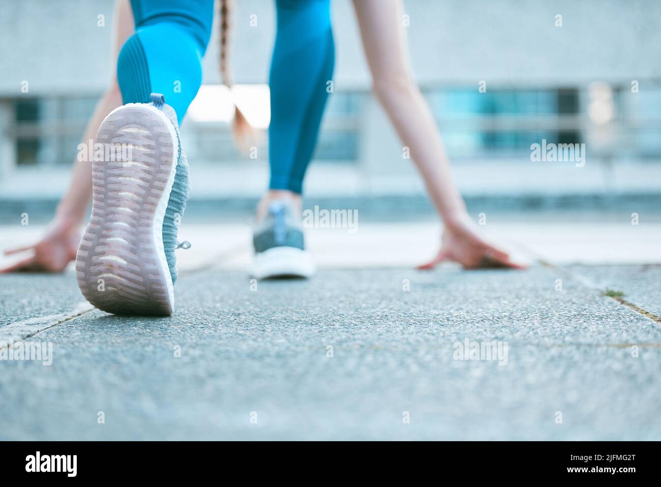 Gros plan de la semelle de chaussures d'une athlète féminine se préparant à courir en position de départ tout en s'exerçant à l'extérieur. Femme sportive portant des chaussures Banque D'Images
