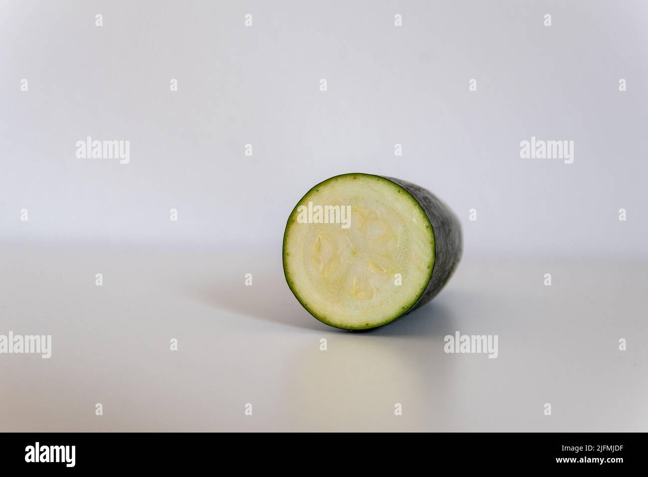 Courgettes en tranches devant un fond blanc Banque D'Images