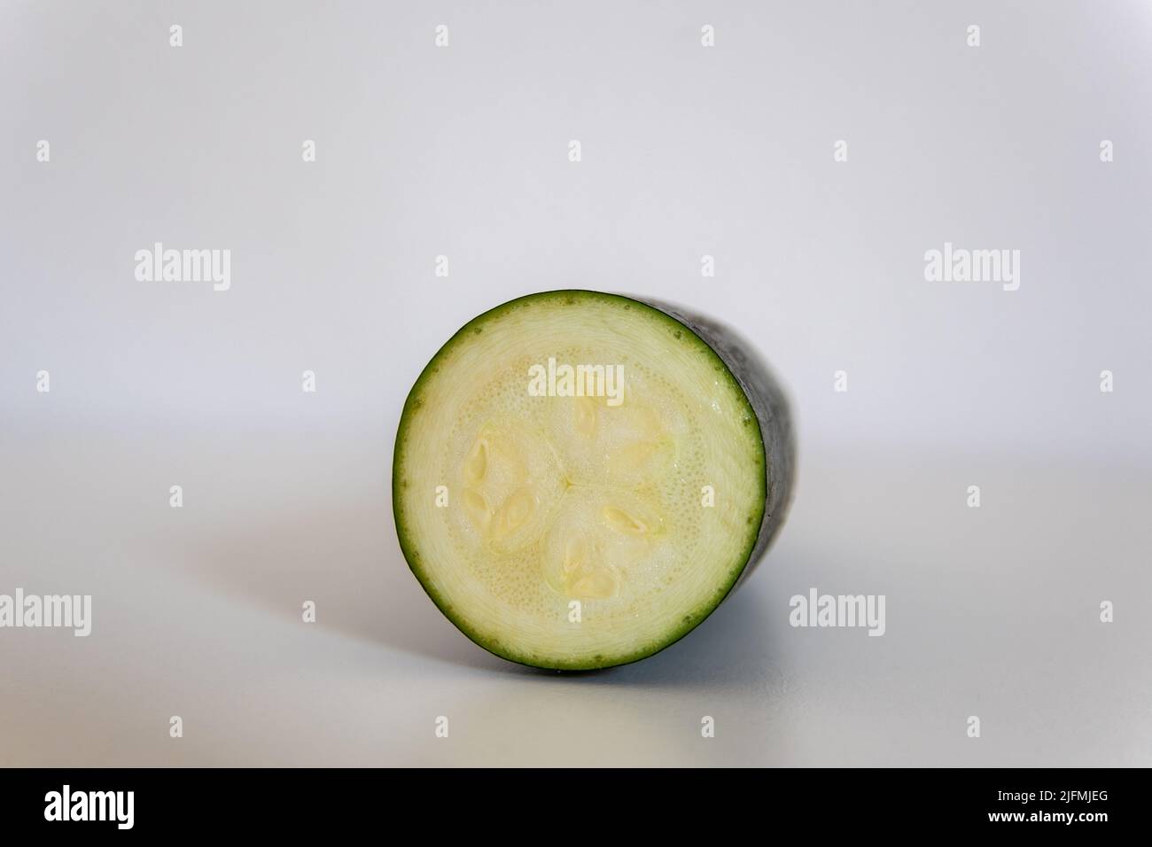 Courgettes en tranches devant un fond blanc Banque D'Images