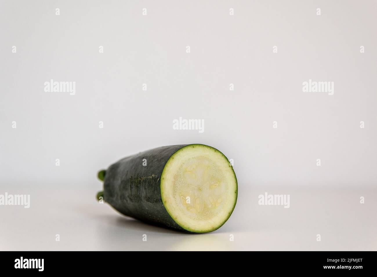Courgettes en tranches devant un fond blanc Banque D'Images