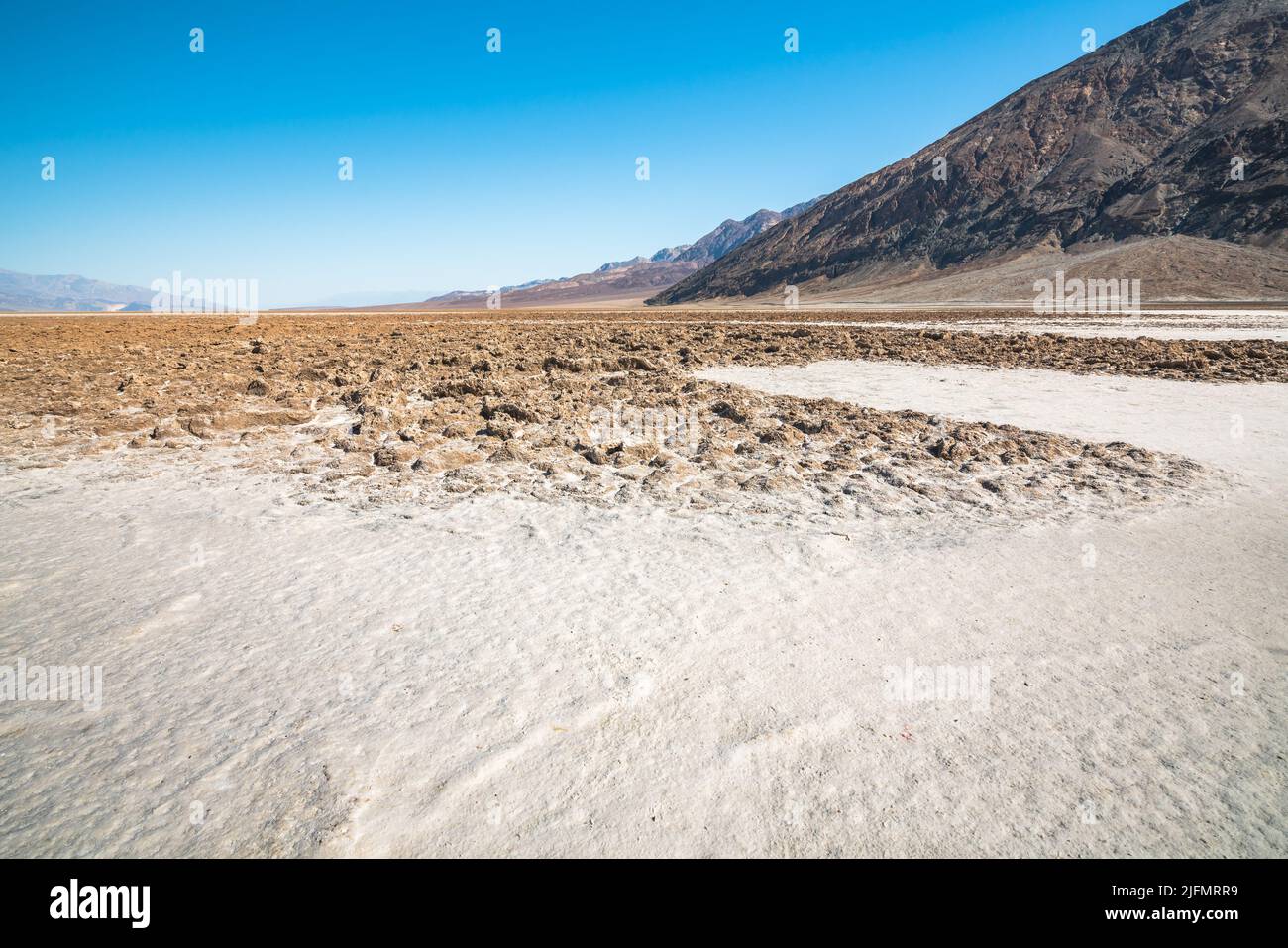 Des salées et des fissures dans la boue dans le parc national de la Vallée de la mort. Bassin de Badwater et montagnes noires Banque D'Images