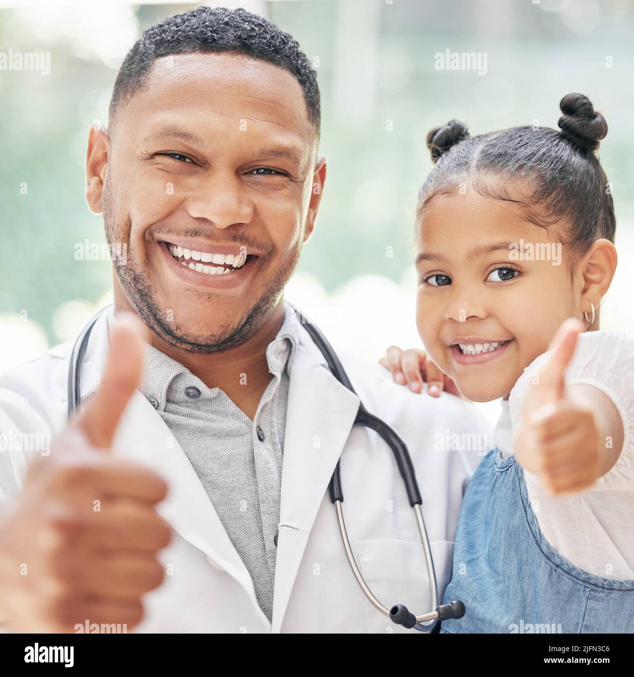 Portrait d'un beau jeune pédiatre noir tenant un adorable petit garçon dans les mains, un enfant mignon et un médecin souriant pendant le contrôle médical à la clinique Banque D'Images