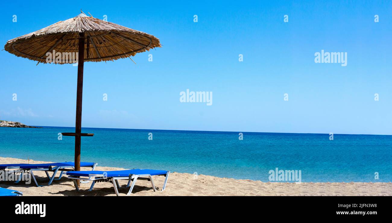 Transats vides sur une plage en Grèce. Deux chaises longues sable blanc, vue sur la mer avec horizon Banque D'Images