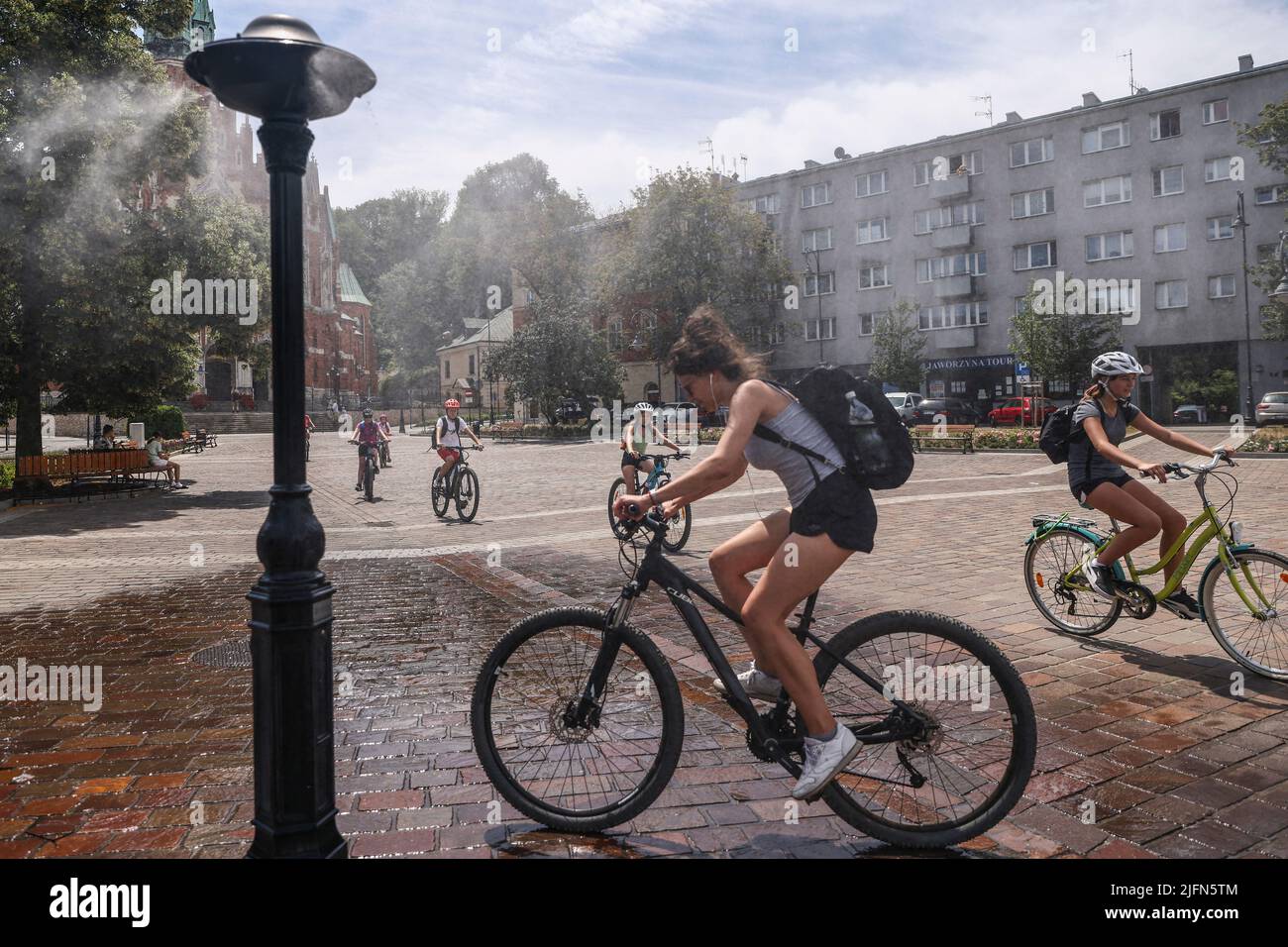 Cracovie, Pologne. 4th juillet 2022. Les personnes qui se trouvent sur les vélos sont en cours de refroidissement à l'eau sprinkleur de la place Podgorski pendant que la vague de chaleur se poursuit. Cracovie, Pologne sur 4 juillet 2022. Les masses d'air chaud de toute l'Afrique couvraient la plus grande partie du pays. (Credit image: © Beata Zawrzel/ZUMA Press Wire) Banque D'Images