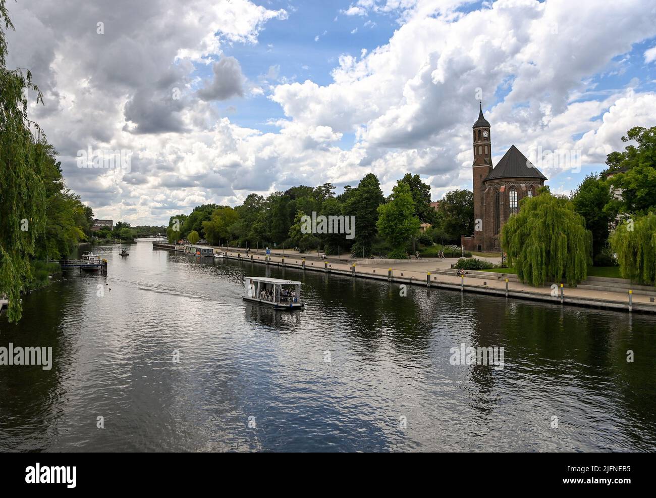 08 juin 2022, Brandebourg, Brandebourg/Havel : un radeau d'excursion est en cours sur la Basse-Havel du Brandebourg, sur le rivage du Salzhof, sur le Jahrtausendbrücke, avec vue sur l'église Saint-Johannes. Photo: Jens Kalaene/dpa Banque D'Images