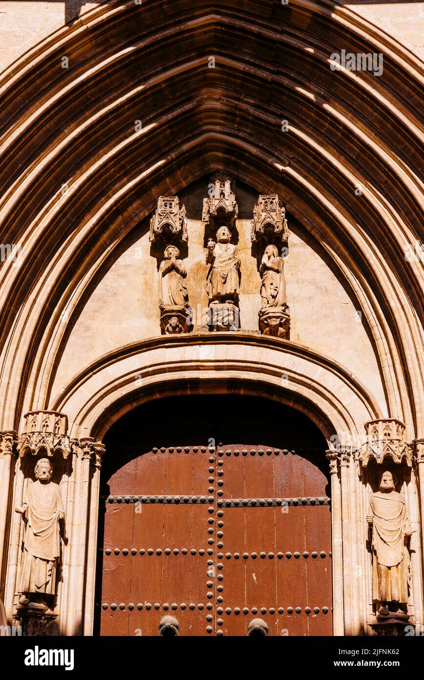 Le portail d'entrée est de style gothique avec une arche à pic flanquée de sculptures sur pied de Saint Pierre et Paul, tandis que le lintel a une mer maladroit Banque D'Images