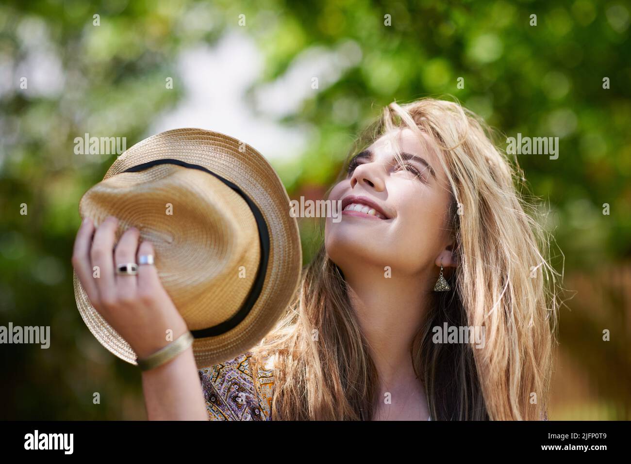 Mère nature, je vous prends mon chapeau. Photo d'une jeune femme branchée qui profite d'une journée dans la nature. Banque D'Images