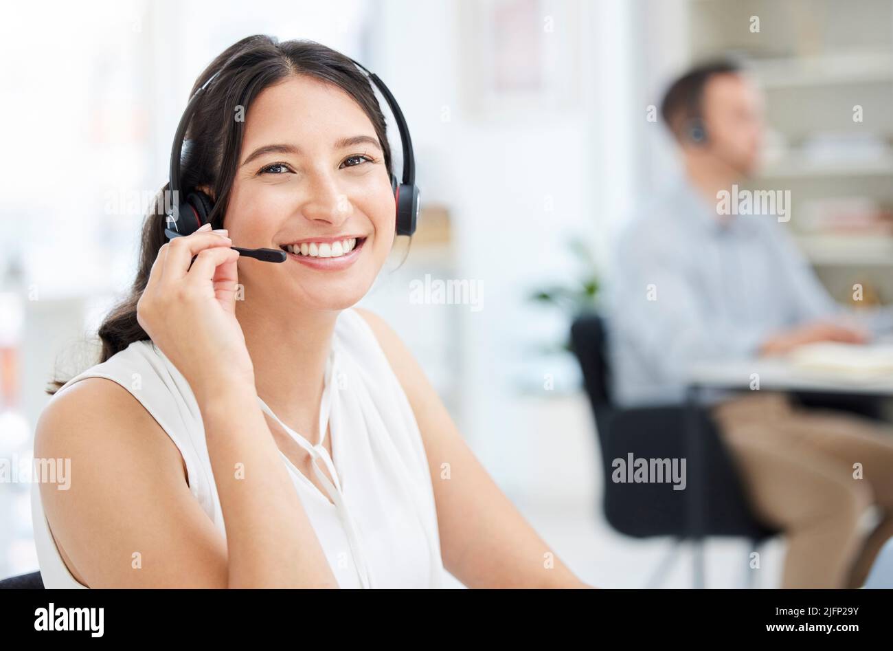 Votre appel est important pour nous. Portrait d'un jeune agent de centre d'appels travaillant dans un bureau. Banque D'Images
