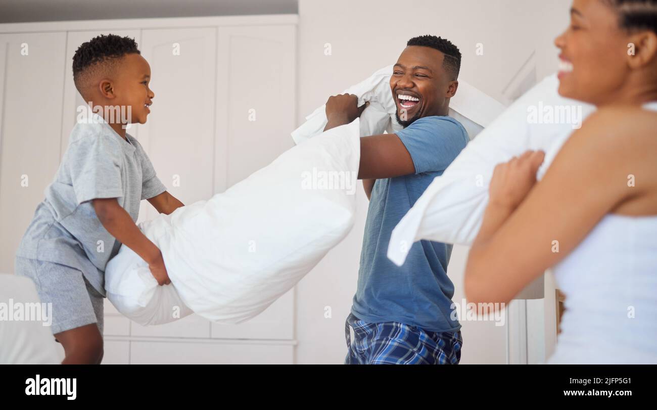 Qui sera couronné champion de combat d'oreiller. Photo d'une famille heureuse ayant un oreiller de combat ensemble à la maison. Banque D'Images