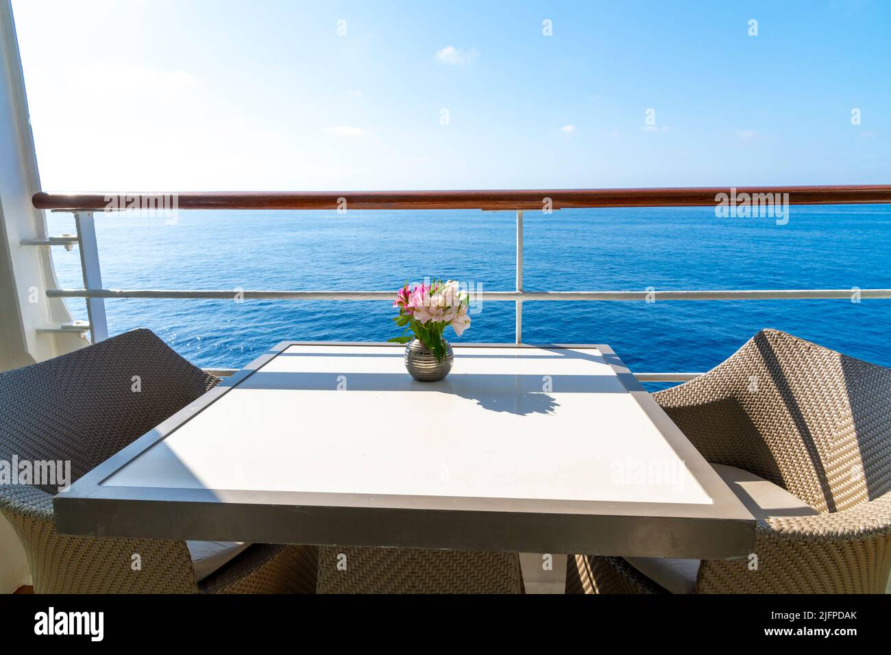 Fleurs sur une table pour deux sur le balcon du pont d'un bateau de croisière de luxe en mer par une journée ensoleillée d'été. Banque D'Images