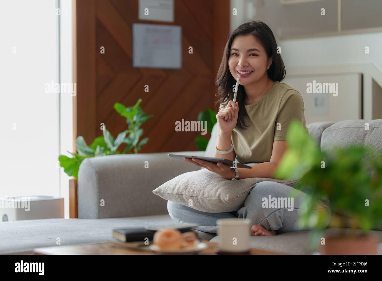 Portrait d'une jeune femme asiatique utilisant les réseaux sociaux pour discuter sur tablette numérique. Style de vie, shopping en ligne, détente sur le canapé. Banque D'Images
