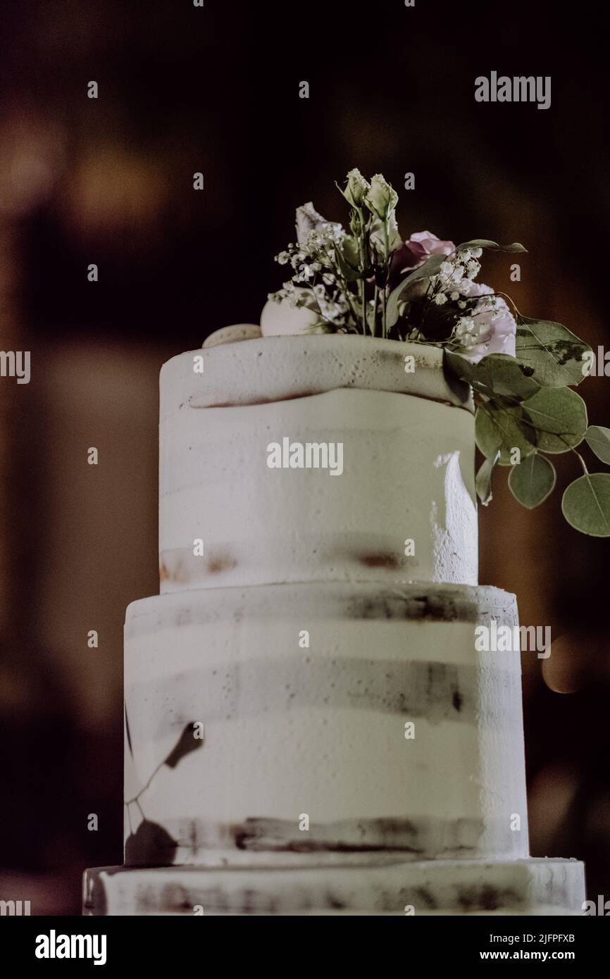 Un gros plan des deux pneus d'un gâteau de mariage décoré de fleurs Banque D'Images