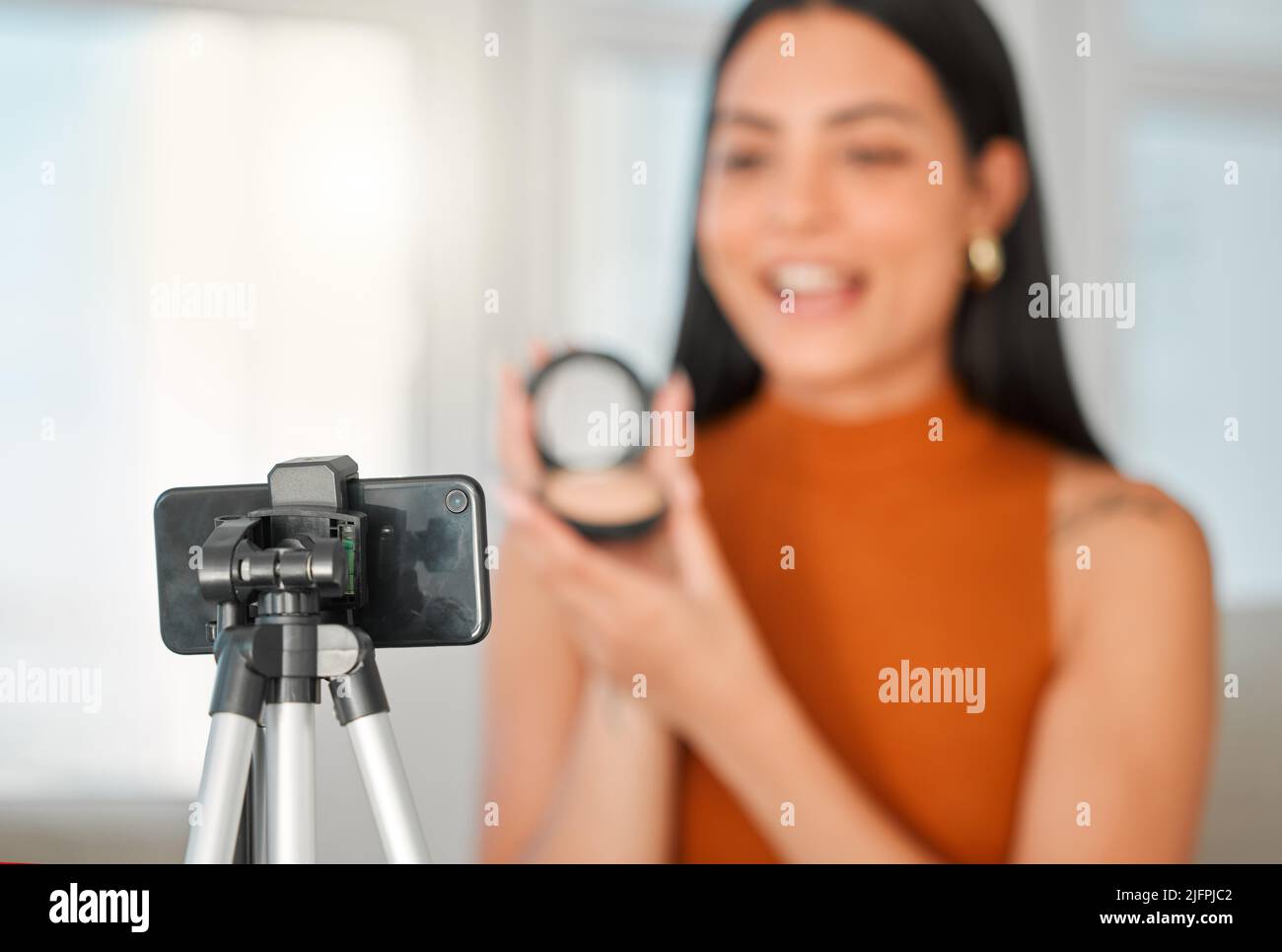 Le temps d'influencer les masses. Prise de vue rognée d'un jeune influenceur de beauté attrayant en streaming depuis son salon à la maison. Banque D'Images