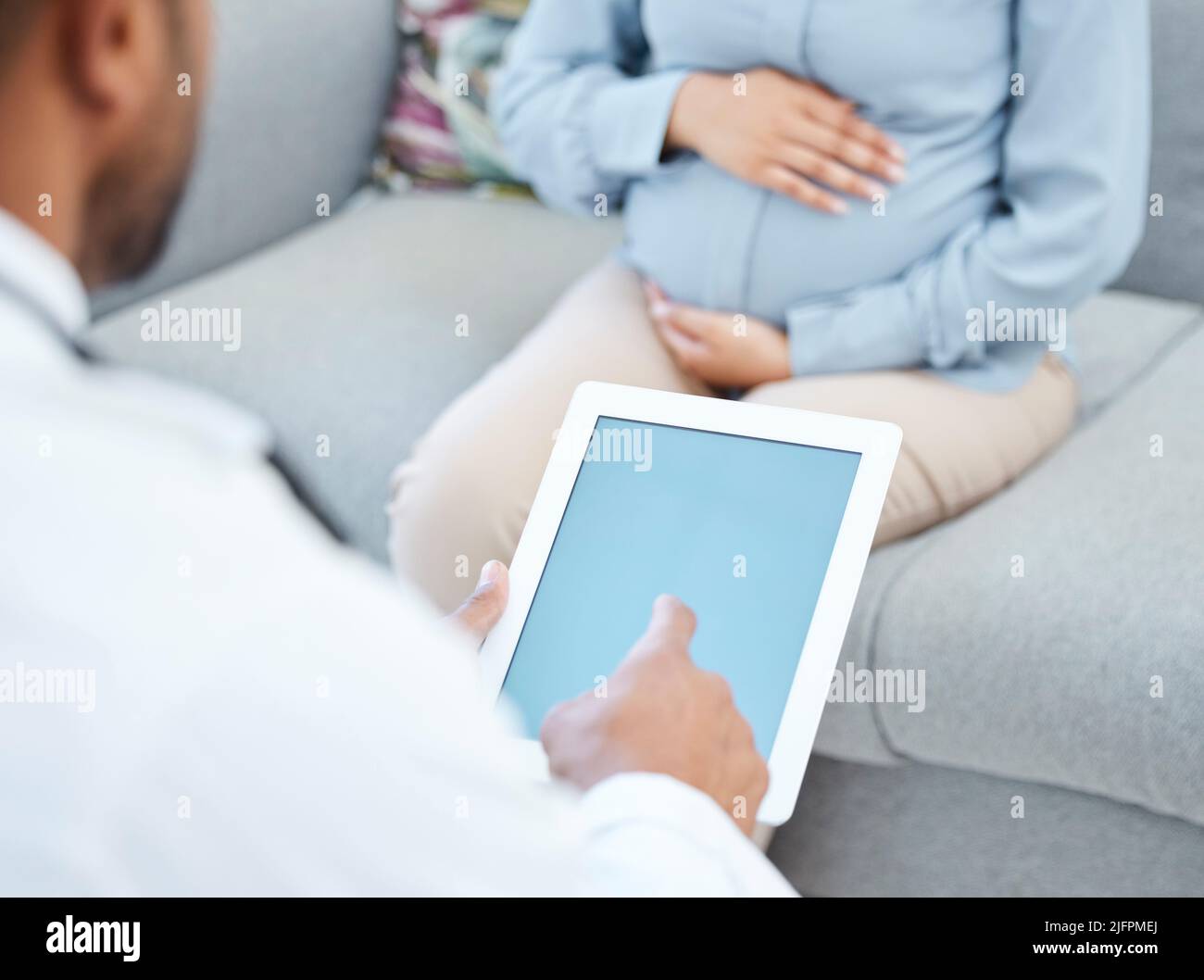 Vous devez vous reposer bien avant l'arrivée du bébé. Gros plan d'un médecin utilisant un comprimé numérique lors d'une consultation avec une femme enceinte dans un Banque D'Images