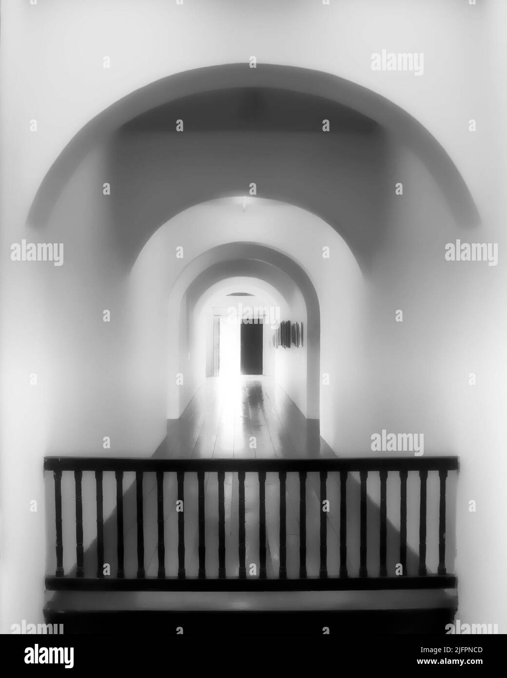 Une lumière éblouissante jaillit dans un couloir vide solitaire par une porte à moitié ouverte, mais une barricade imposante suggère qu'il est impossible de s'échapper de ce couloir Banque D'Images