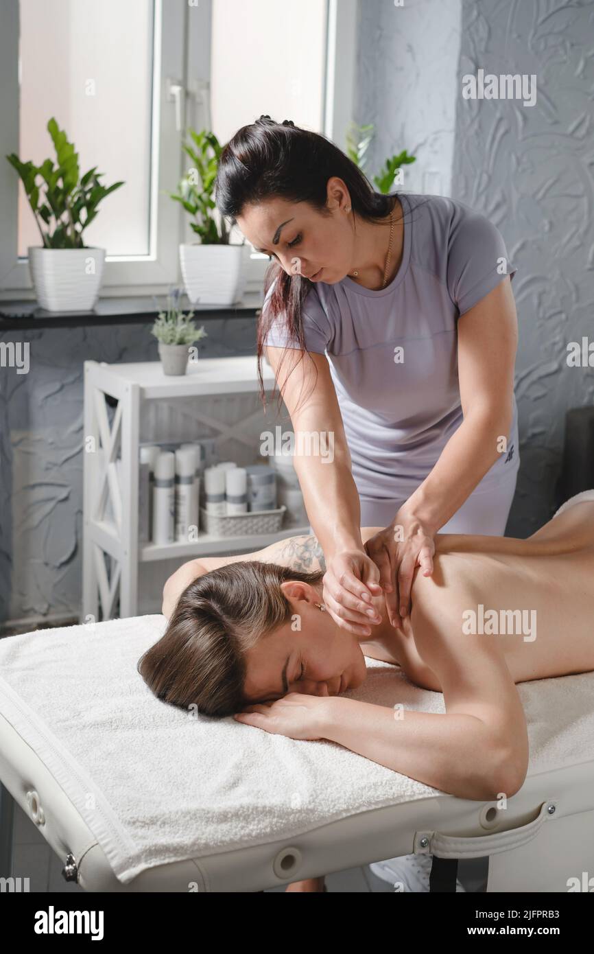 Femme caucasienne ayant un traitement de massage en clinique de thérapie. Massage de dos d'huile, concept de spa et de soins de santé. Soulagement de la douleur. Banque D'Images