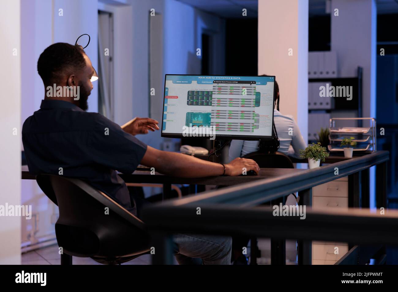Trader de hedge Fund analysant les ventes et les statistiques en temps réel du marché boursier, en utilisant la bourse mondiale pour faire des investissements d'affaires. Suivant la tendance de l'indice de capital avec le commerce de forex la nuit. Banque D'Images