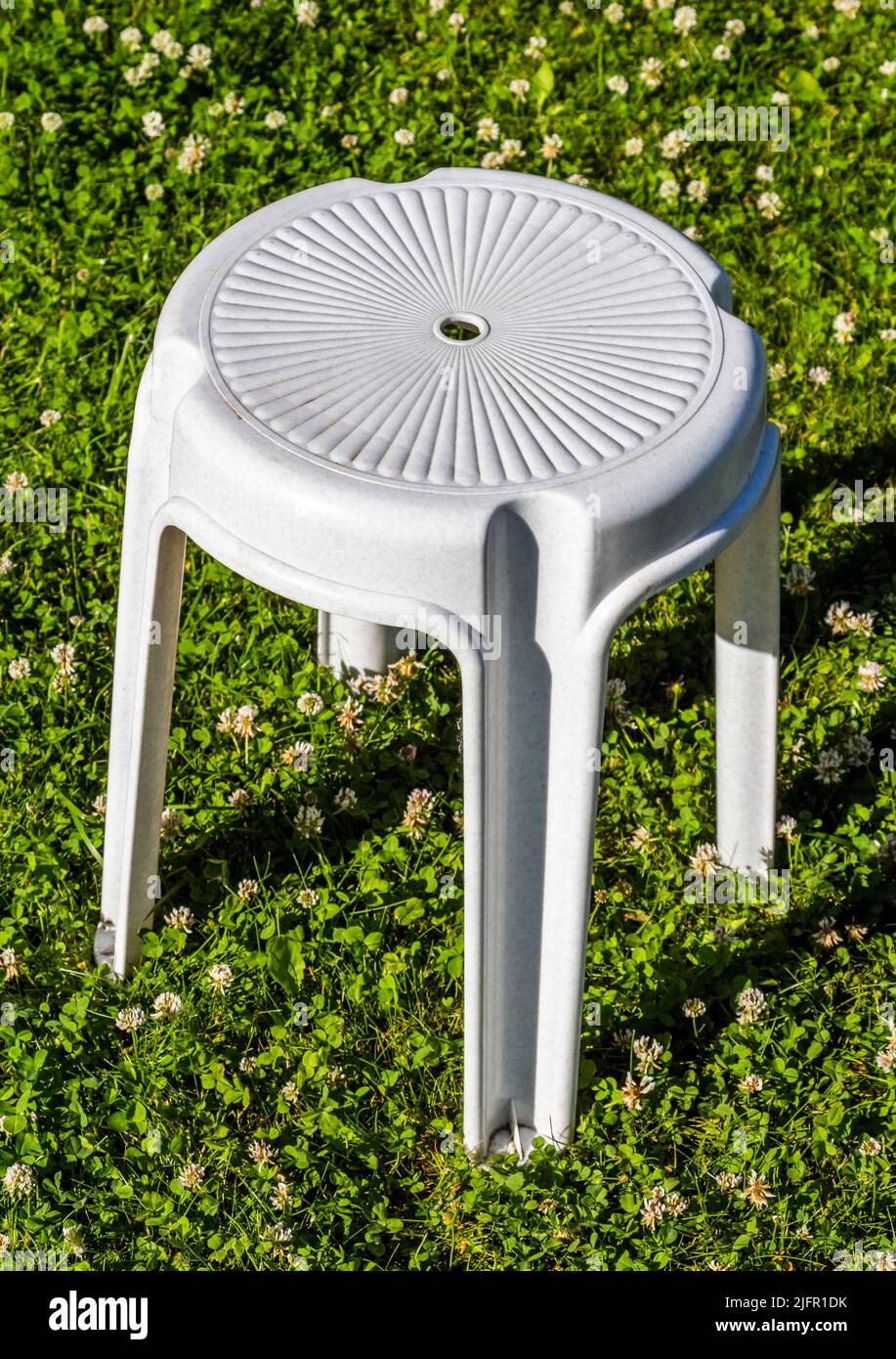 Chaise en plastique blanc gros plan sur un fond d'herbe verte Banque D'Images