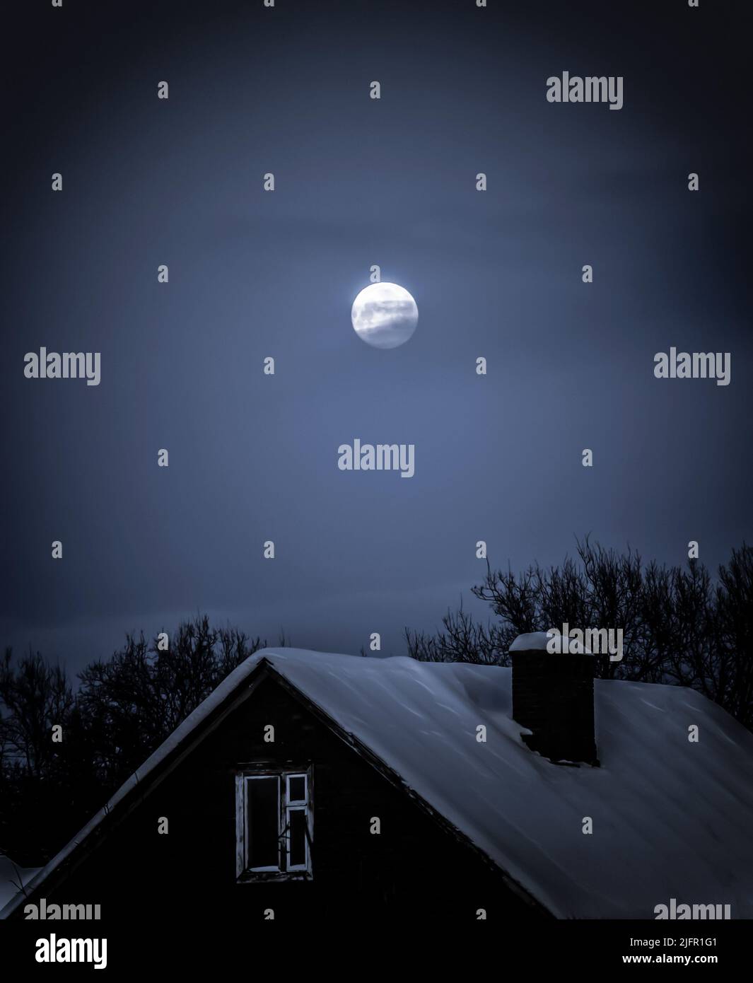 Lonely moon dans la soirée ciel d'hiver sur le village. Banque D'Images