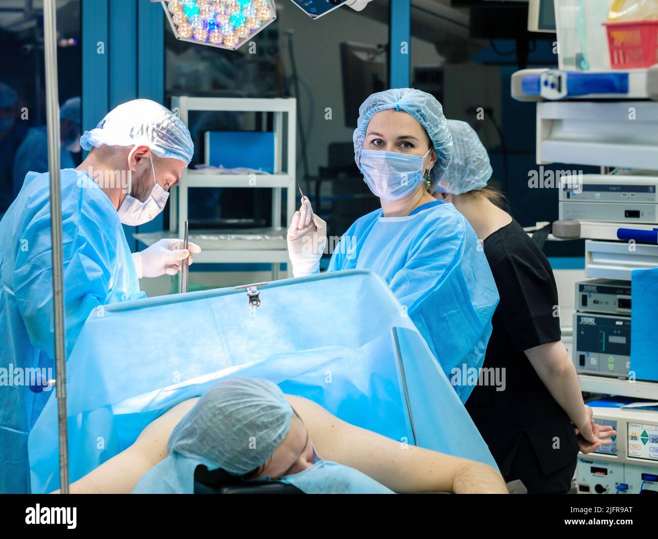 Moscou. Russie. 24 décembre 2021. Jeune femme chirurgien avec scalpel pendant la chirurgie. Les chirurgiens effectuent une chirurgie coloproctologique sur l'anus du patient. Traitement chirurgical des hémorroïdes. Banque D'Images