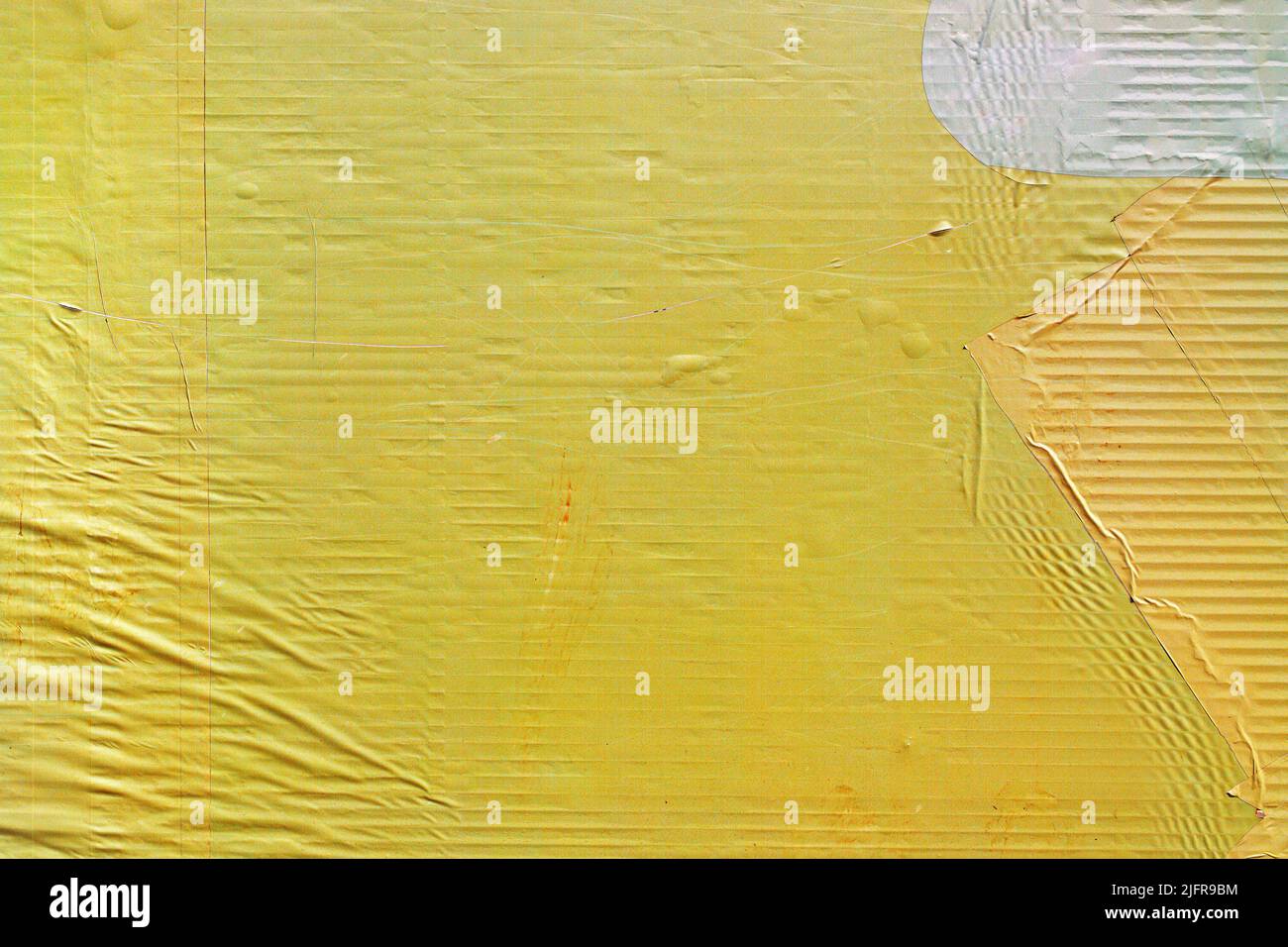 Texture du papier d'affiche publicitaire collé jaune comme fond urbain, usure de la surface de la bannière publicitaire Banque D'Images