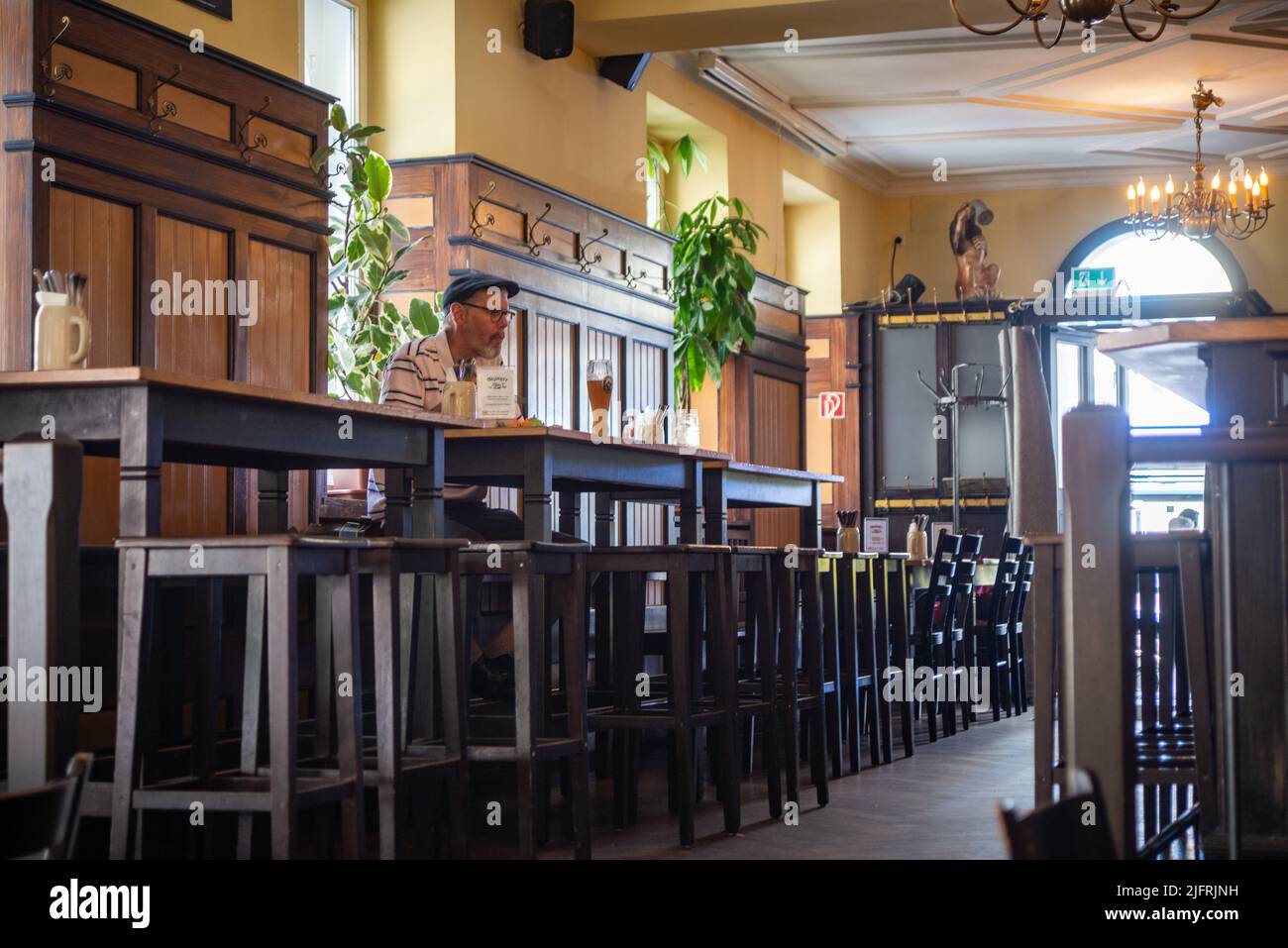 Un patron s'assoit à boire une bière à une table en attendant sa commande. Banque D'Images