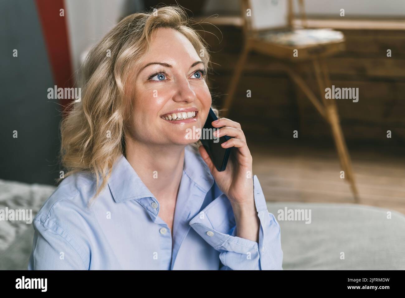 Belle femme parle au téléphone et sourit. Banque D'Images