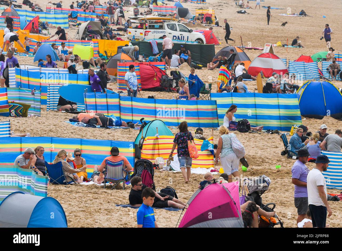 Les vacanciers du Royaume-Uni sur Fistral Beach ont profité du soleil brumeux chaud et de la brise marine rafraîchissante de Cornwall au Royaume-Uni. Banque D'Images
